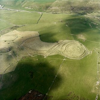 Oblique aerial view centred on the remains of the fort and linear earthwork with the remains of the linear earthwork and pit-alignment adjacent, taken from the SW.