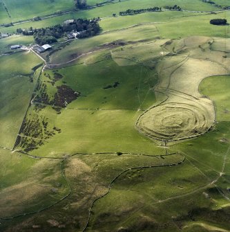 Oblique aerial view centred on the remains of the fort and linear earthwork with the remains of the linear earthwork and pit-alignment adjacent, taken from the SE.