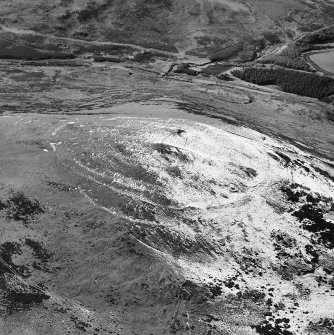 White Meldon, oblique aerial view, taken from the E, centred on the fort and a cairn.