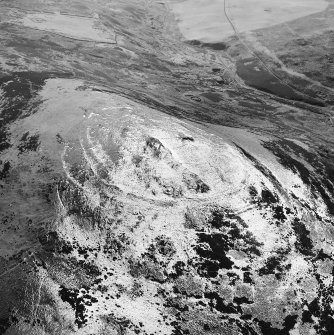 White Meldon, oblique aerial view, taken from the NNE, centred on the fort and a cairn.