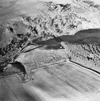 Oblique aerial view centred on the remains of the rig, building and enclosure, taken from the SSE.