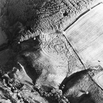 Oblique aerial view centred on the remains of the rig, building and enclosure, taken from the W.