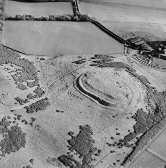 Oblique aerial view centred on the remains of the fort and settlement with rig adjacent, taken from the WNW.