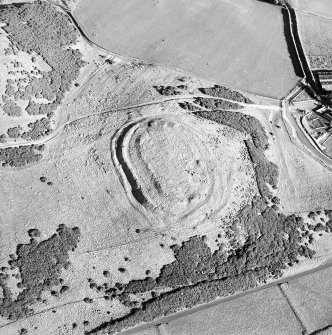 Oblique aerial view centred on the remains of the fort and settlement with rig adjacent, taken from the W.