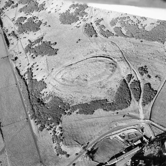 Oblique aerial view centred on the remains of the fort and settlement with rig adjacent, taken from the S.