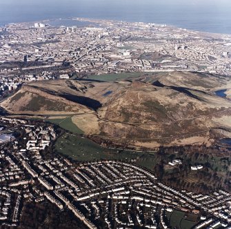 Oblique aerial view of Edinburgh centred on Holyrood Park, taken from the S.