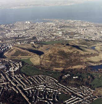 Oblique aerial view of Edinburgh centred on Holyrood Park, taken from the SSW.