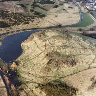 Oblique aerial view of Edinburgh, Holyrood Park centred on the remains of a fort, taken from the ENE.