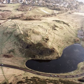 Oblique aerial view of Edinburgh, Holyrood Park centred on the remains of a fort, taken from the NNW.