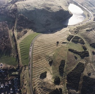 Oblique aerial view of Holyrood Park centred on the remains of rig with a quarry and ring-ditch adjacent, taken from the N.