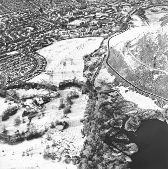 Oblique aerial view of Edinburgh, centred on Holyrood Park, taken from the E.