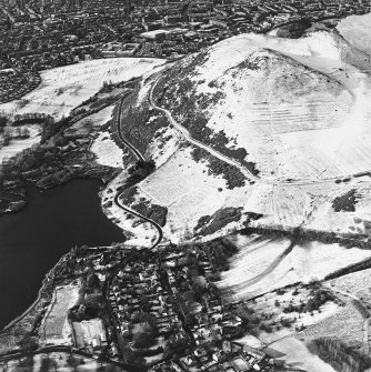 Oblique aerial view of Edinburgh, centred on Holyrood Park, taken from the ENE.