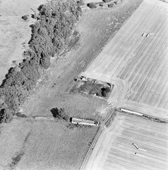 Oblique aerial view centred on the remains of the house with building adjacent, taken from the SW.