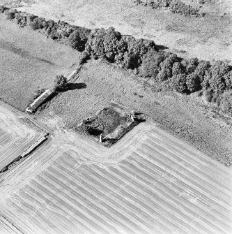 Oblique aerial view centred on the remains of the house with building adjacent, taken from the ESE.