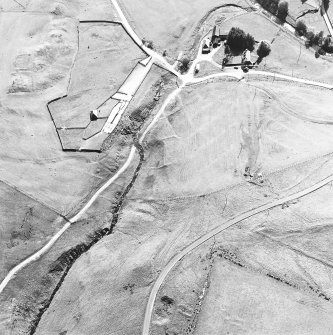 Oblique aerial view centred on the remains of the deserted settlement with the remains of the castle and possible farmstead  adjacent, taken from the NE.