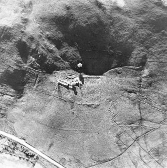 Oblique aerial view centred on the remains of the tower-house, buildings and enclosures, taken from the E.