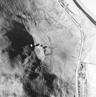 Oblique aerial view centred on the remains of the tower-house, buildings and enclosures, taken from the SW.