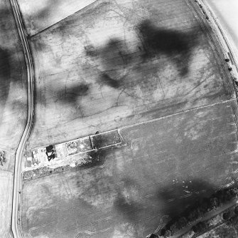 Thornybank, oblique aerial view, taken from the SW, centred on cropmarks including a ring-ditch. A possible settlement is visible in the bottom left-hand corner of the photograph.