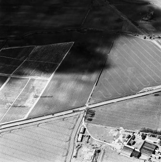 Oblique aerial view of Longthorn and Sheriffhall Mains centred on the remains of coal pits and cropmarks, and farmsteading and farmhouse, taken from the ESE.