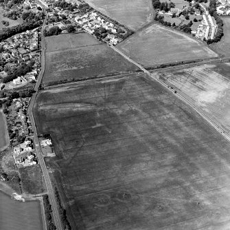 Oblique aerial view centred on the cropmarks of the cursus with the cropmarks of the field-system adjacent, taken from the SSE.