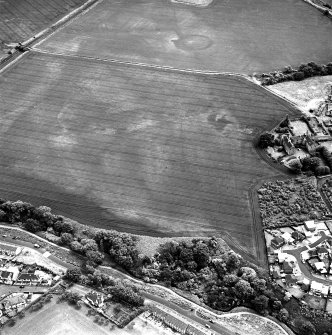 Brunstane, oblique aerial view, taken from the NW, centred on the cropmarks of an enclosure, coal pits and shaft, a possible enclosure and rig.  Other cropmarks are also visible. Brunstane House is visible in the right centre of the photograph.