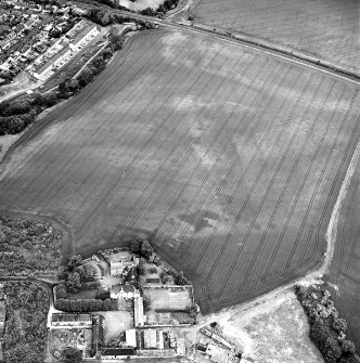 Brunstane, oblique aerial view, taken from the NE centred on the cropmarks of coal pits and shaft, and two enclosures.  Other cropmarks are also visible.  Brunstane House is visible in the left centre of the photograph.