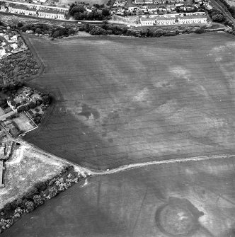 Brunstane, oblique aerial view, taken from the NW, centred on the cropmarks of coal pits and shaft, and two enclosures.  Other cropmarks are also visible.  Brunstane House is visible in the left centre of the photograph.