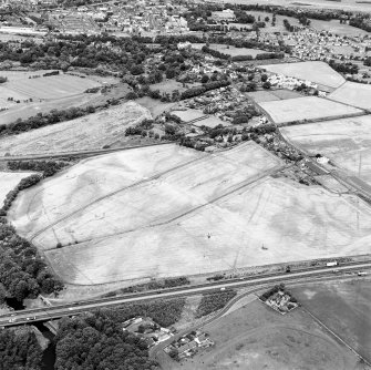 Westfield, Inveresk, oblique aerial view, taken from the N, showing the cropmarks of a cursus monument and internal ring-ditch in the right half of the photograph. The cursus is bisected by the cropmark of a dismantled mineral railway.