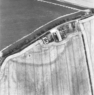 West Mains, oblique aerial view, taken from the SW, centred on the cropmarks of the S half of a fort.