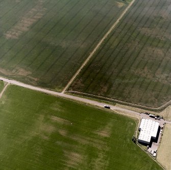 Howe Mire, oblique aerial view, taken from the N, showing cropmarks which include those of a settlement and coal pits in the top right-hand corner of the photograph, and an enclosure in the centre left.