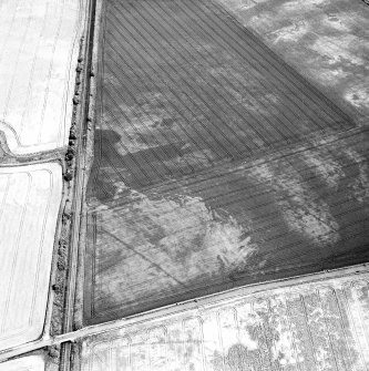 Howe Mire, oblique aerial view, taken from the WSW, centred on a linear cropmark and indeterminate marks. Further cropmarks of a series of coal pits are visible in the top right-hand corner of the photograph.