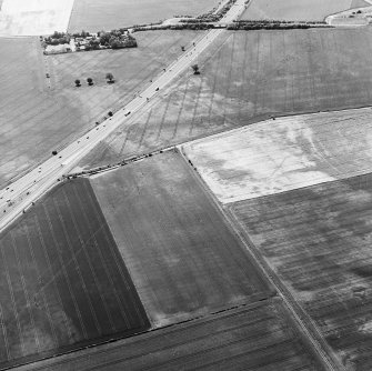 Oblique aerial view centred on the cropmarks of the coal-pits and field-boundary with other cropmarks adjacent, taken from the NE.