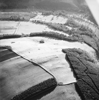 Oblique aerial view centred on the remains of enclosures, taken from the NNE.