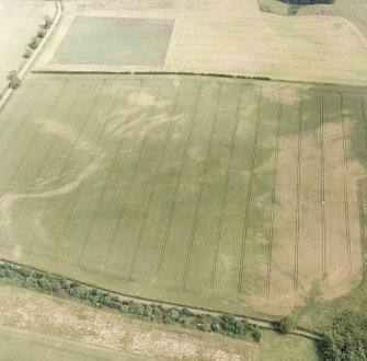 Oblique aerial photograph of Fala Dam, taken from the SW, centred on the cropmarks of a Roman temporary camp.