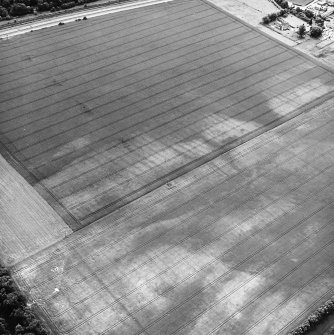 Seton Mains and Longniddry Dean, oblique aerial view, taken from the N, centred on the cropmarks including those of a ring-ditch, a possible settlement, a pit-alignment and rig. A palisaded enclosure is visible in the centre right of the photograph.