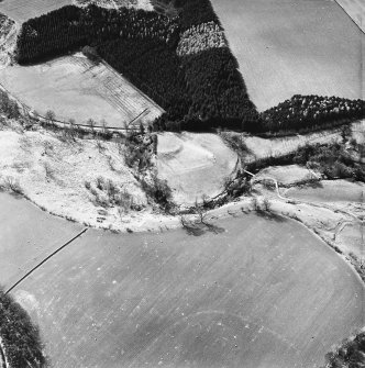 Fast Castle, oblique aerial view, taken from the NE, showing the motte in the centre of the photograph. Immediately to the right a small patch of rig is visible.