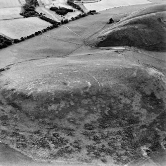 Oblique aerial view centred on the remains of the kerb cairn with rig adjacent, taken from the NW.