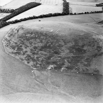 Oblique aerial view centred on the remains of the kerb cairn with rig adjacent, taken from the WNW.