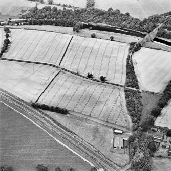 Oblique aerial view of Newstead centred on the cropmarks of the Roman fort, eastern and southern annexes, enclosure and Roman temporary camps, taken from the SE.