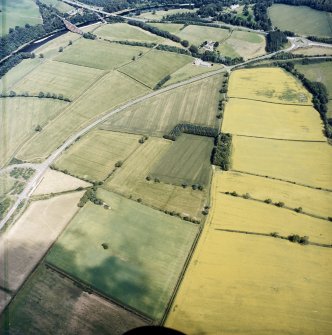 Oblique aerial view centred on the cropmarks of the Roman temporary camps and enclosure with the Roman fort and annexes adjacent, taken from the SW.