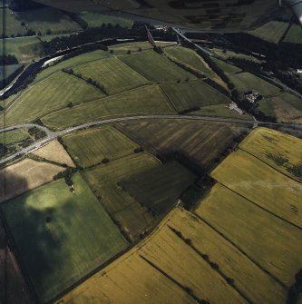 Oblique aerial view centred on the cropmarks of the Roman temporary camps and enclosure with the Roman fort and annexes adjacent, taken from the SSW.