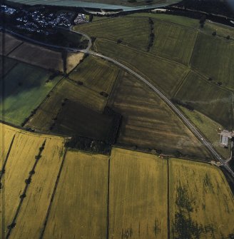 Oblique aerial view centred on the cropmarks of the Roman temporary camps and enclosure with the Roman fort and annexes adjacent, taken from the SE.
