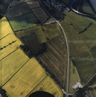 Oblique aerial view centred on the cropmarks of the Roman temporary camps and enclosure with the Roman fort and annexes adjacent, taken from the E.