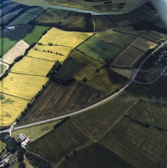 Oblique aerial view centred on the cropmarks of the Roman temporary camps and enclosure with the Roman fort and annexes adjacent, taken from the NE.