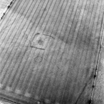 Huntington, oblique aerial view, taken from the NE, centred on the cropmarks of a settlement and a barrow, and showing a linear cropmark in the bottom right-hand corner of the photograph.