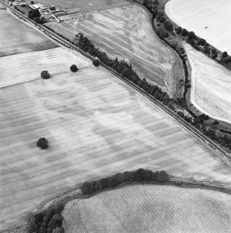 Oblique aerial view centred on the cropmarks of the pit-defined enclosure and field boundary, taken from the S.