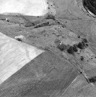 Oblique aerial view centred on the remains of the castle with linear cropmarks adjacent, taken from the SW.
