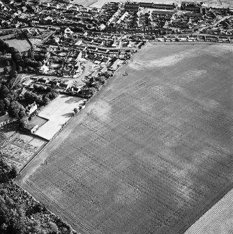 Oblique aerial view of cropmarks including linear croparks, taken from the NE.  Prestonkirk Parish Church is just visible in the middle left of the picture.