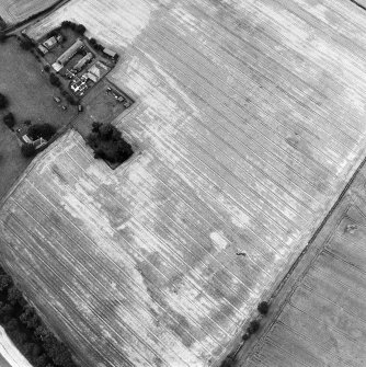 Oblique aerial view centred on the burial-ground, watermill, farmhouse, farmsteading and school, and the cropmarks of the nunnery, taken from the ESE.