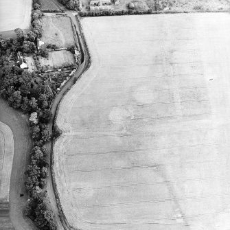 Oblique aerial view centred on the cropmarks of the airship sheds and adjacent circular features, the farmsteading and dovecot, taken from the WSW.